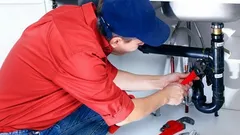 Instalatér opravuje odpad pod dřezem, instalatérské práce, údržba potrubí kuchyně.