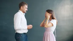 Muž nabízí zásnubní prsten překvapené ženě na šedém pozadí