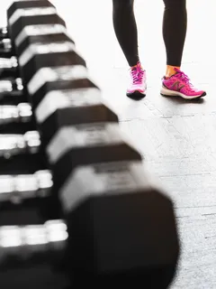 osoba v růžových teniskách Nike na šedém pozadí