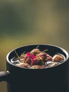 Hrnec s vodou a květinami na stole