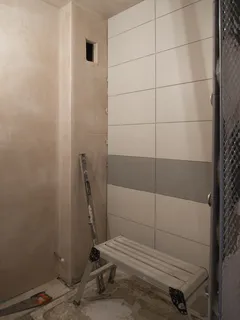 Moderní koupelna s lavičkou a obklady na stěnách pro domácí renovaci
