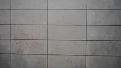 Bílá mramorová podlahová dlažba u betonové zdi
