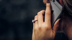 Zásnubní prsten vedle iPhonu 6s na stole
